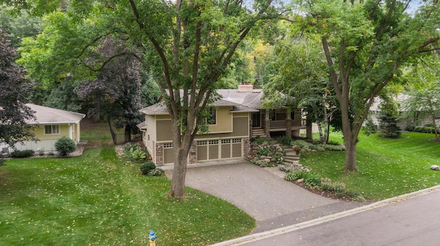 view of front of home featuring a garage, a chimney, stairs, and a front lawn