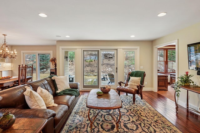 living area featuring recessed lighting, baseboards, wood-type flooring, and a chandelier