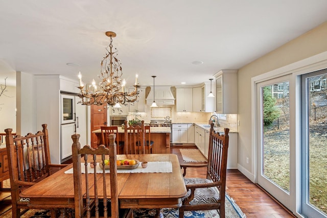 dining area with a notable chandelier, baseboards, and wood finished floors