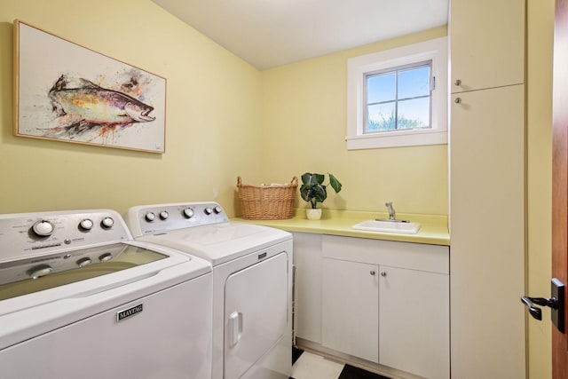 washroom featuring cabinet space, separate washer and dryer, and a sink