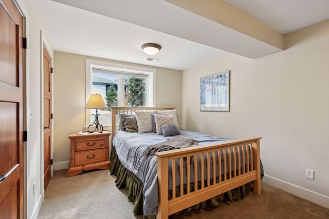bedroom featuring light carpet and baseboards