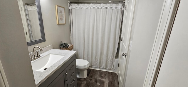 full bathroom featuring hardwood / wood-style flooring, shower / bathtub combination with curtain, vanity, and toilet