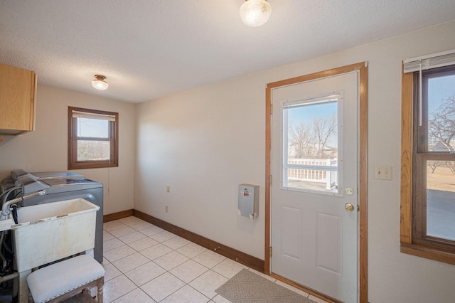 laundry room with independent washer and dryer, cabinets, a textured ceiling, and light tile patterned flooring