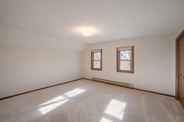 carpeted empty room featuring a baseboard radiator, vaulted ceiling, and a textured ceiling