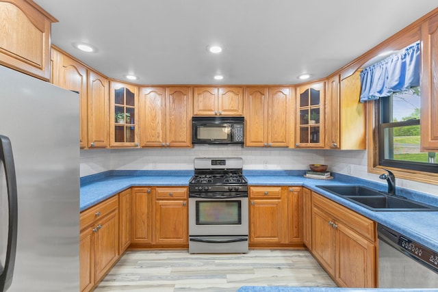 1697 Shore Dr, Arthur Twp, MN 55051 - kitchen featuring stainless steel appliances, a sink, light wood-style flooring, glass insert cabinets, and recessed lighting