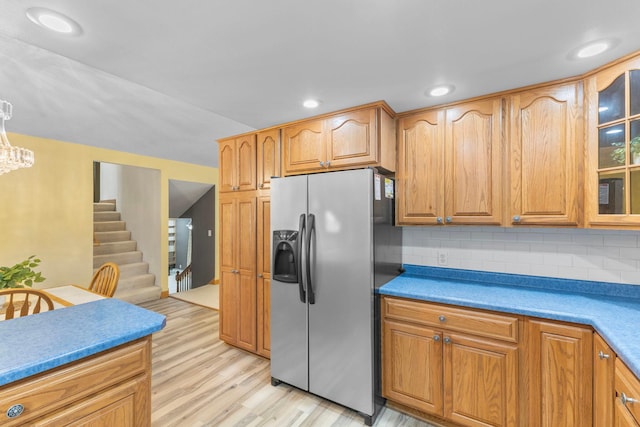 1697 Shore Dr, Arthur Twp, MN 55051 - kitchen with stainless steel refrigerator with ice dispenser, light wood-style flooring, glass insert cabinets, backsplash, and a chandelier