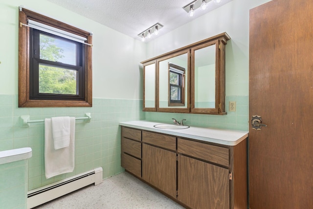 1697 Shore Dr, Arthur Twp, MN 55051 - bathroom with tile walls, baseboard heating, vanity, wainscoting, and a textured ceiling