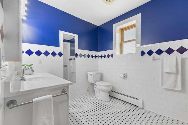 1697 Shore Dr, Arthur Twp, MN 55051 - half bathroom featuring a baseboard heating unit, tile walls, a wainscoted wall, toilet, and vanity