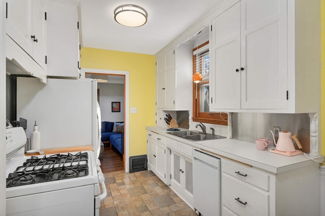 kitchen with white appliances, sink, and white cabinets