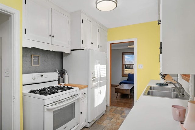 kitchen with white cabinetry, sink, and white appliances