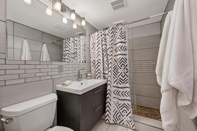 bathroom with toilet, tile walls, vanity, a shower with shower curtain, and decorative backsplash