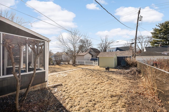 view of yard featuring a sunroom and a storage shed