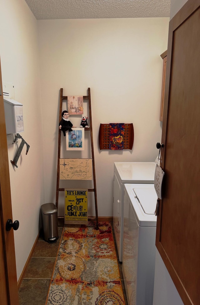 clothes washing area featuring independent washer and dryer, dark tile patterned flooring, and a textured ceiling