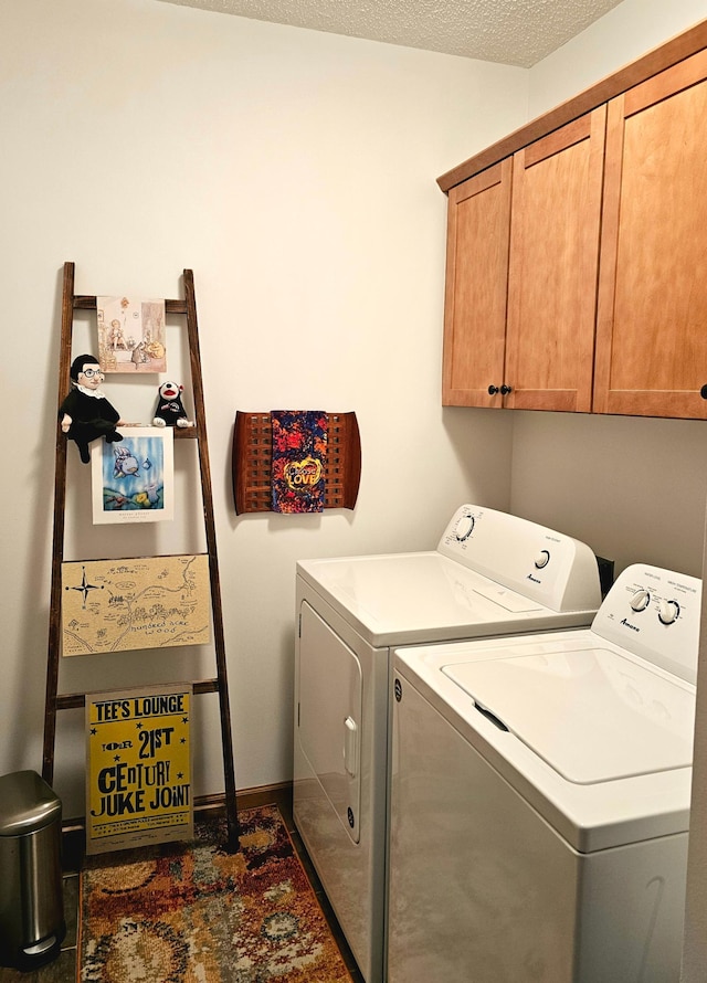 laundry area featuring cabinet space, washer and clothes dryer, and a textured ceiling