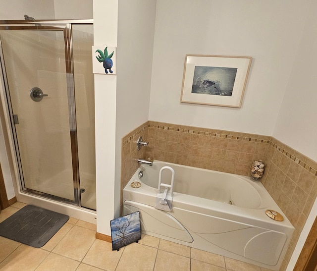 bathroom featuring a stall shower, a garden tub, and tile patterned floors