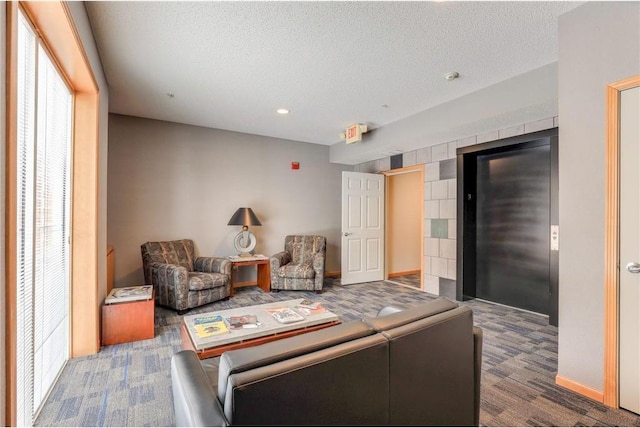 living area with a textured ceiling, dark carpet, and baseboards