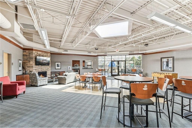 carpeted dining area featuring a stone fireplace