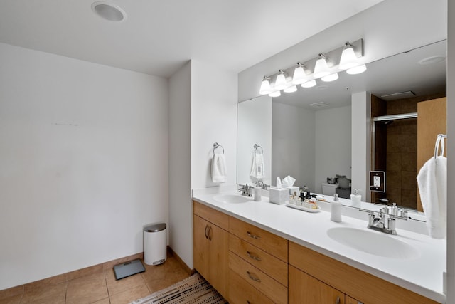 bathroom with tiled shower, vanity, and tile patterned flooring