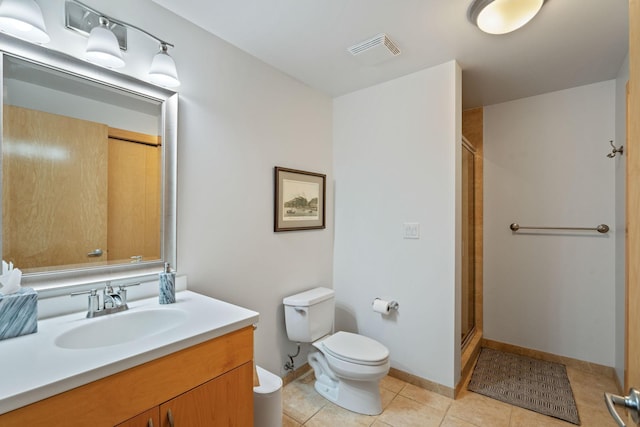 bathroom with a shower with door, vanity, tile patterned floors, and toilet