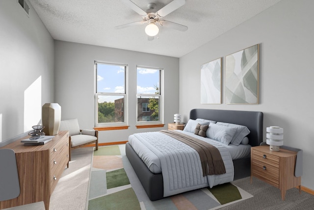 carpeted bedroom with ceiling fan and a textured ceiling