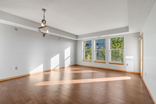 empty room with hardwood / wood-style flooring and a textured ceiling