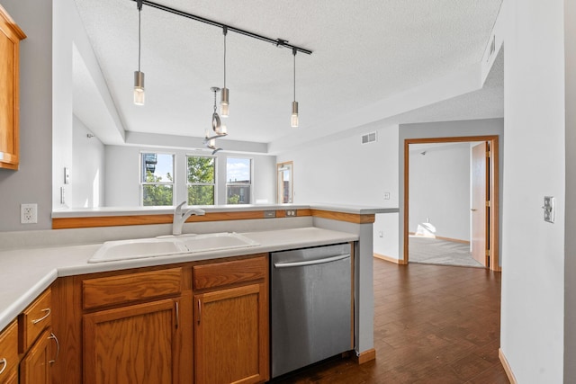 kitchen featuring stainless steel dishwasher, kitchen peninsula, sink, and hanging light fixtures