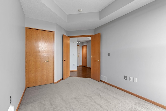 unfurnished bedroom featuring a closet, carpet flooring, and a textured ceiling