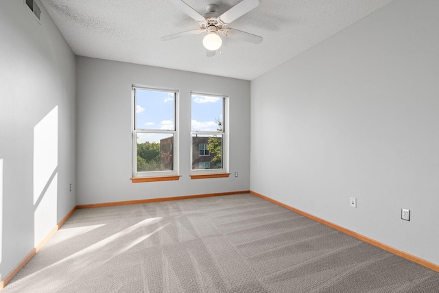 carpeted spare room with ceiling fan and a textured ceiling