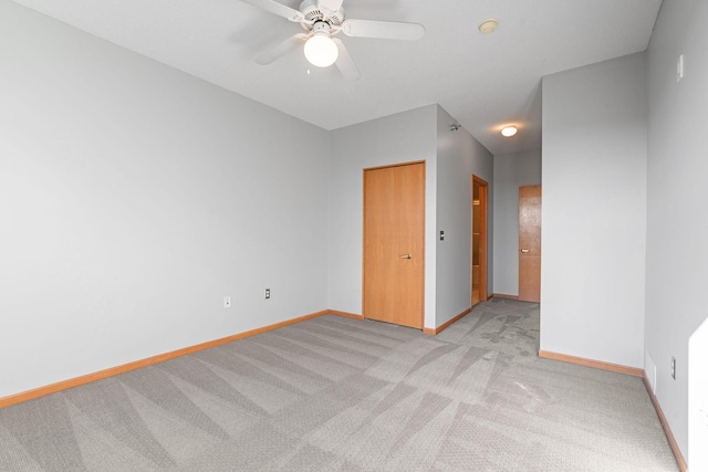 carpeted spare room featuring ceiling fan