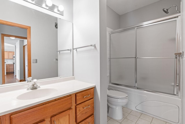 full bathroom featuring vanity, toilet, tile patterned flooring, and combined bath / shower with glass door