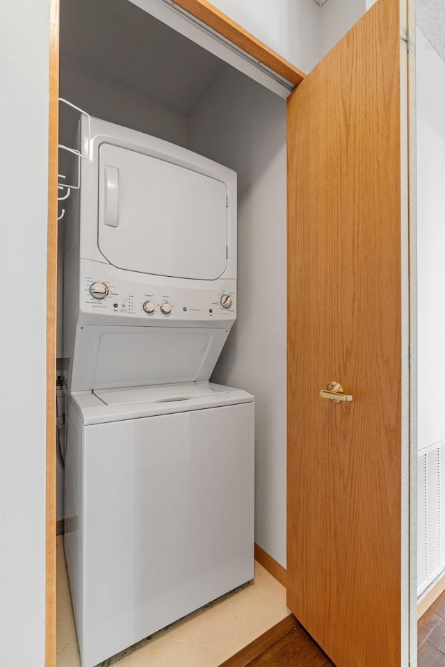 clothes washing area featuring stacked washer and dryer