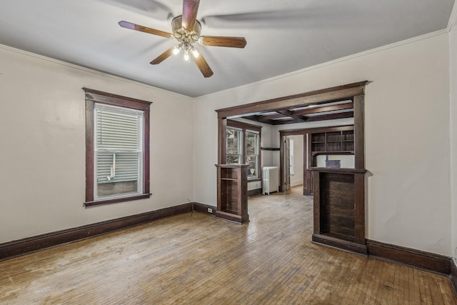 unfurnished room with hardwood / wood-style floors, crown molding, and ceiling fan