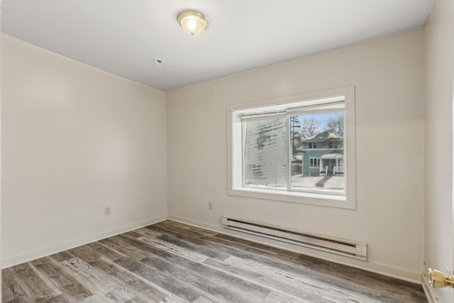 empty room with hardwood / wood-style flooring and a baseboard radiator