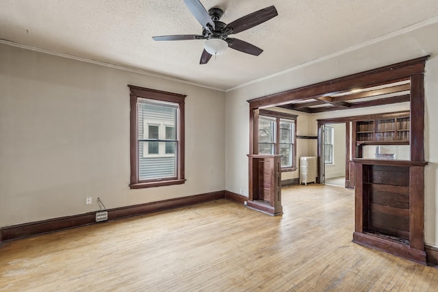 interior space with ceiling fan, ornamental molding, light hardwood / wood-style flooring, and a textured ceiling