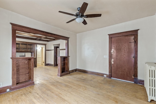 unfurnished living room featuring ceiling fan, ornamental molding, radiator heating unit, and light hardwood / wood-style floors