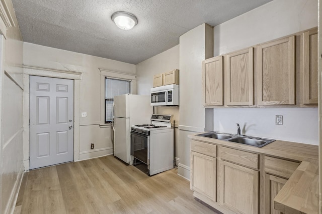 kitchen featuring white appliances, light hardwood / wood-style floors, sink, and light brown cabinets