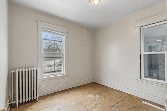 empty room featuring radiator and light hardwood / wood-style floors