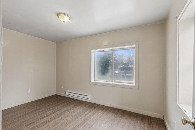 spare room with a baseboard radiator and hardwood / wood-style floors