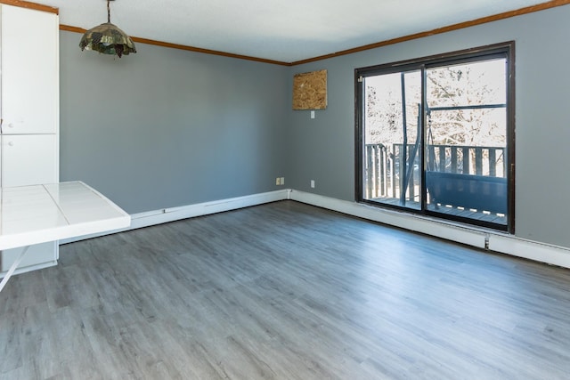 spare room featuring crown molding and wood-type flooring