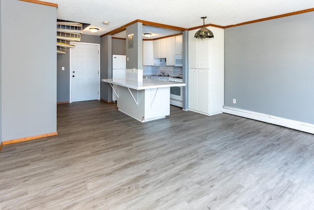 kitchen featuring crown molding, hanging light fixtures, white appliances, hardwood / wood-style floors, and white cabinets