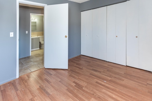 unfurnished bedroom featuring light hardwood / wood-style floors and a closet