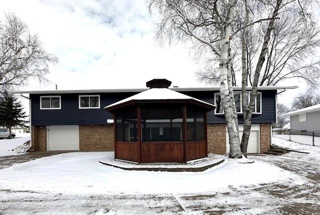 view of front of home featuring a garage and a sunroom