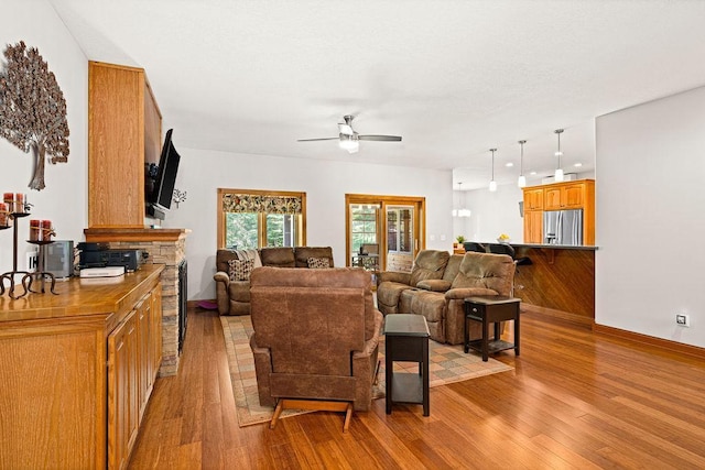 living room featuring ceiling fan and light hardwood / wood-style flooring