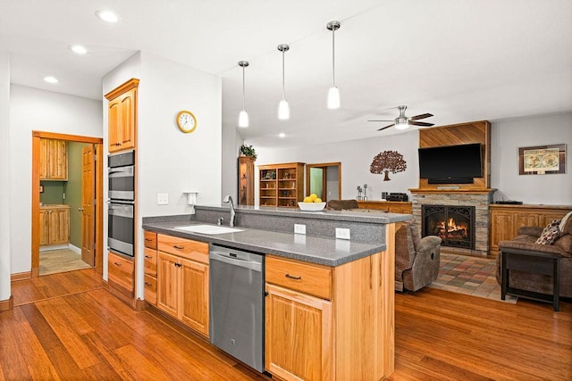 kitchen featuring appliances with stainless steel finishes, decorative light fixtures, dark hardwood / wood-style flooring, and sink