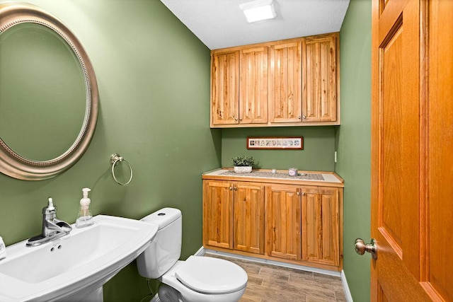 bathroom featuring sink, hardwood / wood-style flooring, and toilet