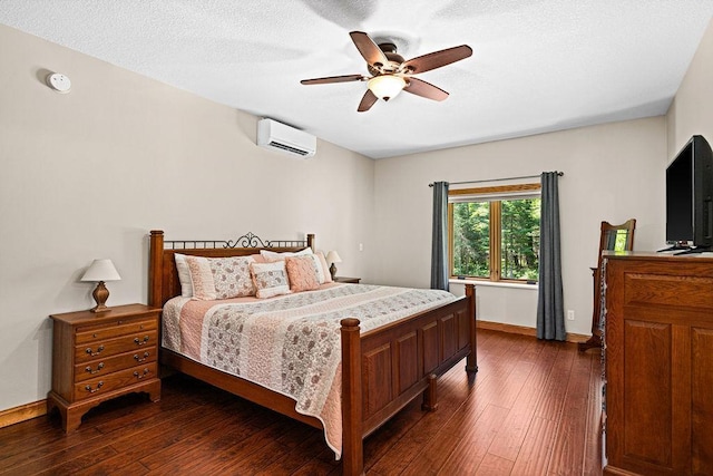 bedroom with ceiling fan, dark hardwood / wood-style flooring, a textured ceiling, and an AC wall unit