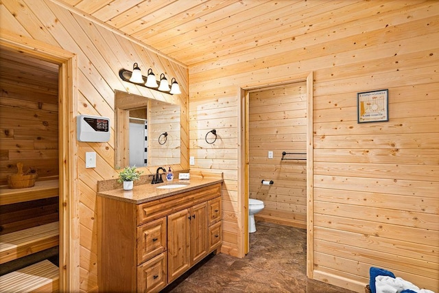 bathroom featuring wooden walls, vanity, and toilet