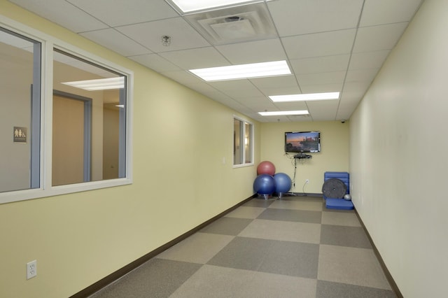 workout room featuring baseboards, dark floors, visible vents, and a drop ceiling