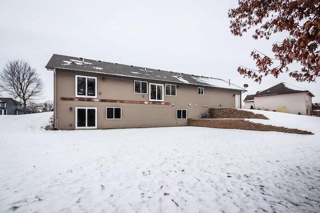 view of snow covered back of property