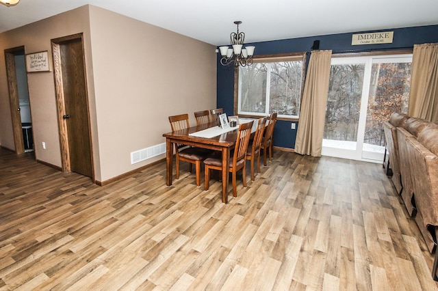 dining room featuring an inviting chandelier and light hardwood / wood-style flooring